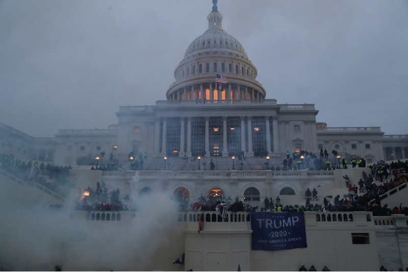 U.S Capitol covered in smoke and Trump flags